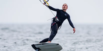 Kite school - Saisonzeiten: Juli - Schleswig-Holstein - Kiter_mit_foil_board_im_Meer.png - Gold Kiteacademy Kiteschule Fehmarn